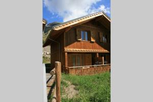 a wooden house with a fence in front of it at Chalet cosy Duplex 6 personnes in Saint-Sorlin-dʼArves