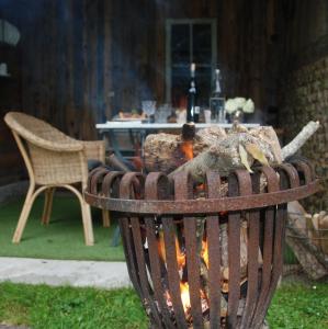 una hoguera en un patio con una mesa en Bergerie de la Moutonnière, en Le Pin