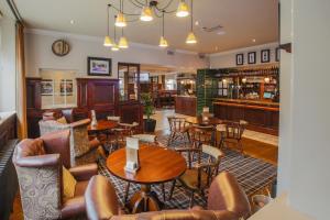 a restaurant with tables and chairs and a bar at Norfolk Arms in Glossop