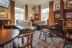 a restaurant with tables and chairs and a bar at Norfolk Arms in Glossop