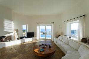 a living room with a white couch and a coffee table at Zen Residence in Lia beach in Kalafatis