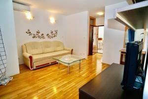 a living room with a couch and a glass table at Apartments Villa Plaza in Trogir
