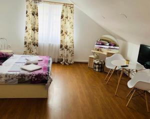 a bedroom with a bed and a table and chairs at Unser Haus in Sibiu