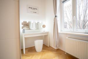 a white bathroom with a sink and a mirror at Cozy Modern Nest in the Heart of Vienna with Netflix in Vienna