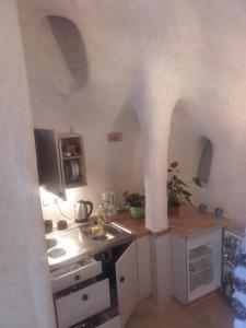 una pequeña cocina con arcos en la pared en Αura Cave, en Fira