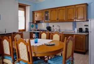 a kitchen with a wooden table and chairs and a table and a kitchen with at La Collina dei Ciliegi in Sarule
