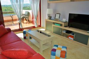 - un salon avec un canapé rouge et une télévision dans l'établissement Vista Bahía, à Casares