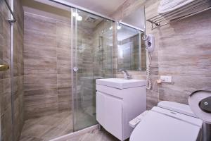 a bathroom with a toilet and a glass shower at Greeninn Hotel in Taipei