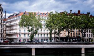 a bridge over a river in front of buildings at Boscolo Lyon Hotel & Spa in Lyon