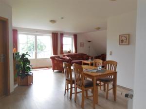 een woonkamer met een tafel en stoelen en een bank bij Ferienhof Christian und Antje Hopp in Fehmarn