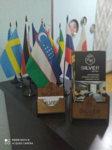 a table with a bunch of different flags on it at Silver Hotel in Tashkent