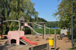 un parque con un parque infantil con un tobogán y una pista en Maison du Pêcheur en Vielsalm