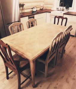 Koniakowo - dom Pinto في كونيكاو: طاولة وكراسي خشبية في مطبخ