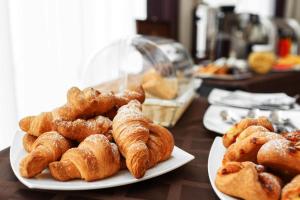 a table with plates of croissants and other pastries at Villa Cornaro Tourist Suites in Santo Stefano di Zimella