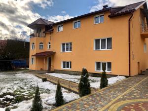 a building with snow in front of it at Sadyba Domashniy zatyshok in Pilipets