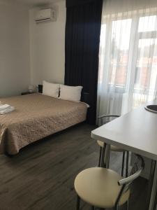una camera d'albergo con letto, tavolo e finestra di Neopolis a Polyana