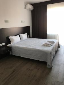 1 dormitorio con 1 cama con sábanas blancas y ventana en Neopolis en Polyana