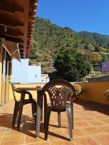 uma mesa e cadeiras numa varanda com uma montanha em La casita de Abi! em La Orotava