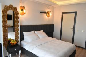 a bedroom with a large bed and a mirror at Avcılar Garden Hotel in Avcılar