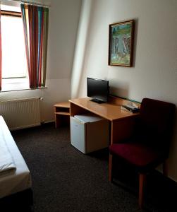 een kamer met een bureau met een computer en een stoel bij Hotel-Pension ODIN in Berlijn