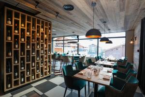 ein Restaurant mit Tischen und Stühlen und einer Fensterwand in der Unterkunft Résidence Prestige Odalys Mendi Alde in La Clusaz