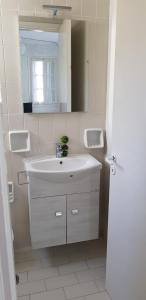 a white bathroom with a sink and a mirror at Cascade Holiday Resort in Poros