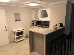 a kitchen with a counter and chairs in a room at Ostseeblick Rügen in Binz