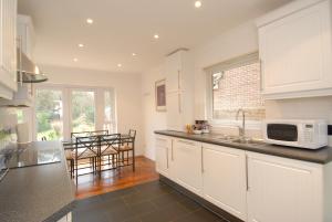 a kitchen with white cabinets and a counter top at Abacus Bed and Breakfast, Blackwater, Hampshire in Camberley