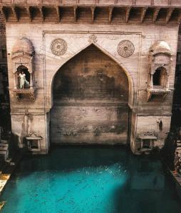 an archway in a building with blue water at JHANKAR Haveli in Jodhpur