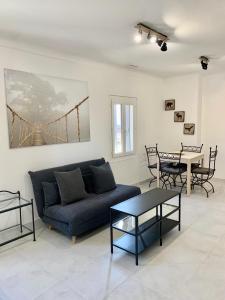 a living room with a blue couch and a table at T2 bis cosy climatisé, Intra Muros Avignon in Avignon