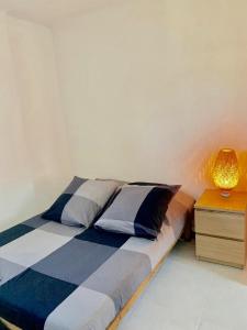 a bedroom with a bed with a lamp on a night stand at T2 bis cosy climatisé, Intra Muros Avignon in Avignon +2 photos