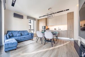 un soggiorno con divano blu e tavolo di Apartamenty Sun & Snow Okrzei a Sopot
