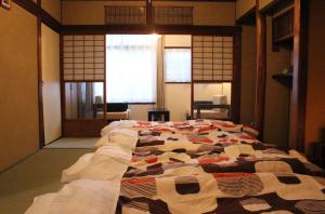 a large bed in a room with windows at Guesthouse Higashiyama Jao in Kyoto