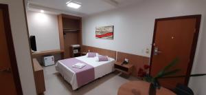 a hotel room with a bed and a tv at Guines Palace Hotel in Patrocínio +37 photos