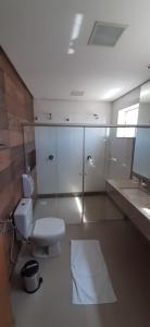 a bathroom with a toilet and a sink and a mirror at Guines Palace Hotel in Patrocínio