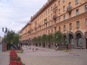 a city street with a large building and flowers at KAZA APART in Minsk