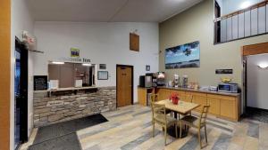 a waiting room with a table and a counter and a kitchen at Waconia Inn and Suites in Waconia