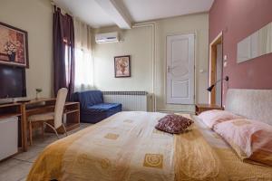 Un dormitorio con una cama, un escritorio y un televisor. en B&B Bebinac, en Leskovac