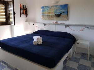 a bedroom with a blue bed with two towels at Formentera Es Pujols 2 camere vicinissimo alla spiaggia in Es Pujols
