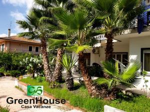 a house with palm trees in front of it at Greenhouse in Mascalucia