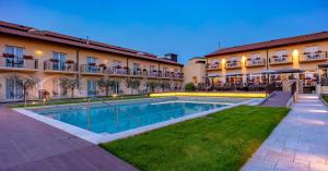 a hotel with a swimming pool in front of a building at Leonardo Hotel Lago di Garda - Wellness and Spa in Lazise