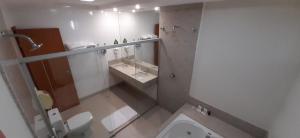 a bathroom with a toilet and a sink and a mirror at Guines Palace Hotel in Patrocínio