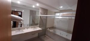 a bathroom with two sinks and a large mirror at Guines Palace Hotel in Patrocínio