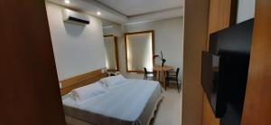a hotel room with a bed and a small table at Guines Palace Hotel in Patrocínio