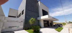 a black and white building with a car parked outside at Guines Palace Hotel in Patrocínio