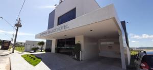 a white building with a sign on the front of it at Guines Palace Hotel in Patrocínio