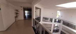a hallway with white walls and a staircase in a house at Guines Palace Hotel in Patrocínio