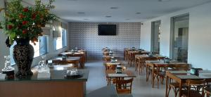 a restaurant with tables and chairs and a vase of flowers at Guines Palace Hotel in Patrocínio