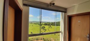 a window with a view of a field of cows at Guines Palace Hotel in Patrocínio