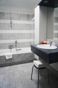 a bathroom with a sink and a bath tub at Hotel Prins Boudewijn in Knokke-Heist